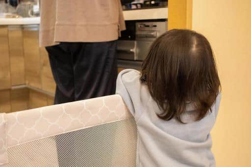 ベビーゲート前で幼児が母親を眺めている