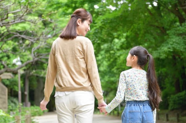 手をつなぐ親子（母と娘）